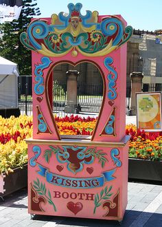 a pink and blue machine sitting on top of a flower garden filled with lots of flowers