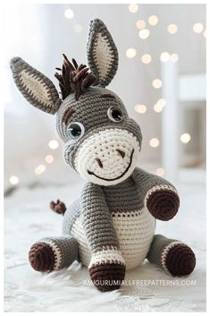 a crocheted donkey sitting on top of a bed