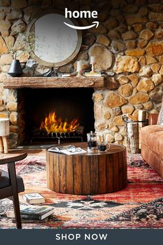 a living room filled with furniture and a fire place in front of a stone wall