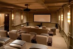 an empty theater with seats and a projector screen in the middle of the room