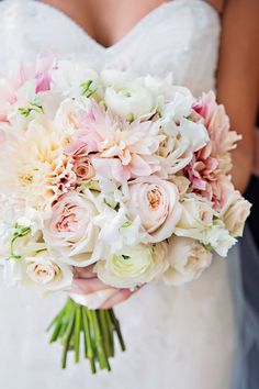 a bridal holding a bouquet of white and pink flowers