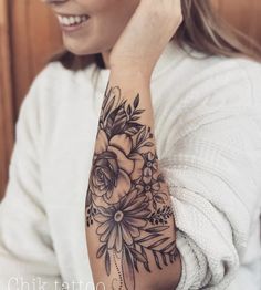 a woman with a flower tattoo on her arm