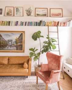 a living room filled with furniture and bookshelves next to a painting on the wall