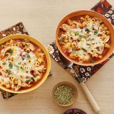 two bowls of pasta with cheese and herbs