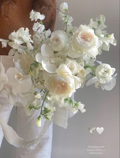 a woman holding a bouquet of white flowers