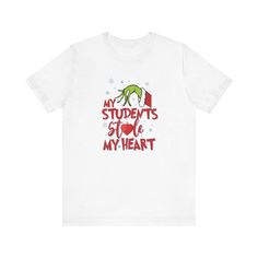 A cute and playful short sleeve tee featuring the design 'Grinch: My Students Stole My Heart'. Perfect for educators who want to show their love for teaching. This tee is great for casual wear and can be easily layered for different looks. Ideal for teachers to wear during holidays like Christmas or Teacher Appreciation Week. Product features - Made with 100% lightweight cotton for breathability - Retail fit for casual and semi-formal settings - Side seams for structural support - Ribbed knit collar with seam for shape retention - Tear-away label for minimal skin irritations Care instructions - Machine wash: cold (max 30C or 90F) - Non-chlorine: bleach as needed - Tumble dry: low heat - Iron, steam or dry: medium heat - Do not dryclean Grinch Shirt, Educator Gifts, Grinch Shirts, Holiday Apparel, School Staff, Teacher Appreciation Week, Teacher Tshirts, Christmas Tees, T Shirt Funny