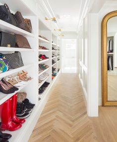 there are many shoes and purses on the shelves in this room, all lined up