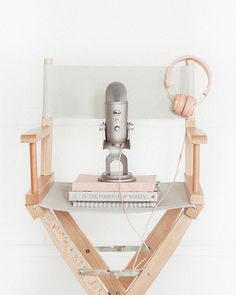 a microphone sitting on top of a wooden stand with headphones hanging from it's sides