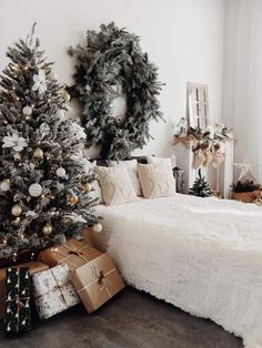 a bedroom decorated for christmas with presents under the tree and wreaths on the wall