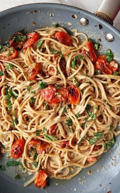 pasta with tomatoes and herbs in a pan