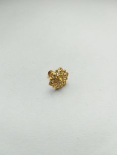 a small gold ring on a white surface