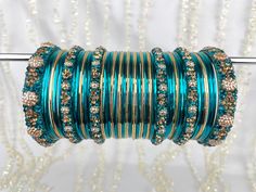 The perfect fusion of tradition and style, designed to elevate your outfit with elegance and charm. This stunning bangle set offers the versatility you've been searching for, as it can be tailored to adorn either one hand or both, ensuring that you shine in any setting. This set includes a total of 24 colored bangles, carefully selected to complement a wide range of outfits and moods. 2 stunning Kara bangles add a touch of mystique and allure to your ensemble, and 4 Churi bangles provide a captivating contrast to your look. To maintain a balance we've also included 11 plain insert bangles, offering a clean and classic finish to your overall aesthetic. Traditional Turquoise Bracelets For Wedding, Crystal Bangle, Bangle Set, Indian Jewellery, Gold And Silver, Indian Jewelry, Bangle Bracelets, Jewelry Bracelets, Etsy Accessories