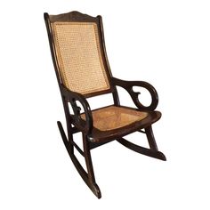 a wooden rocking chair with wicker seat and armrests on an isolated white background