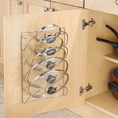 a kitchen cabinet door is open to reveal a wine rack with six glasses on it