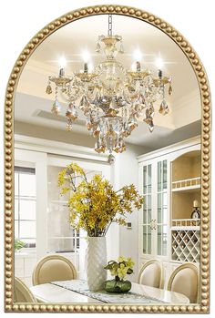 a vase filled with yellow flowers sitting on top of a table under a chandelier