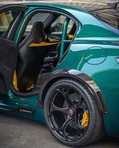 a green car with its door open on the street