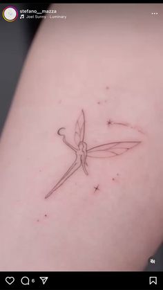 a small tattoo on the back of a woman's arm with scissors in it