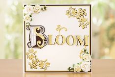 a close up of a greeting card with flowers on the front and bottom that says bloom