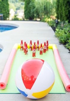 an inflatable beach ball sitting on top of a mat next to a pool