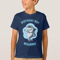 a young boy wearing a birthday boy t - shirt with a shark on the front