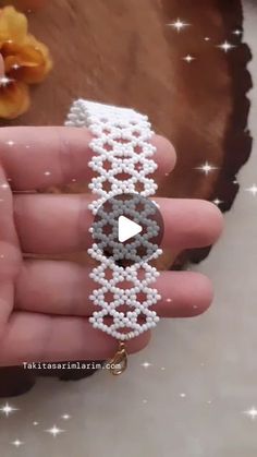 someone is holding a beaded bracelet in their hand and it looks like they are making something out of beads