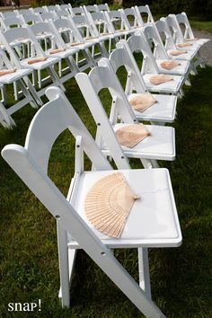 rows of white folding chairs with seashells on them