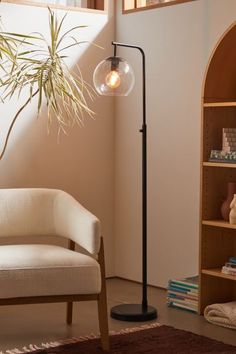 a living room with a chair, lamp and bookshelf