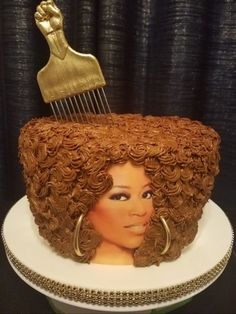 a cake that has been decorated to look like a woman's head with a hair comb on top