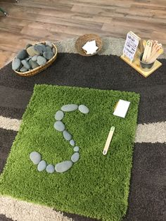 a green rug with rocks in the shape of a smiley face