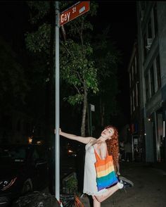 a woman leaning up against a street sign