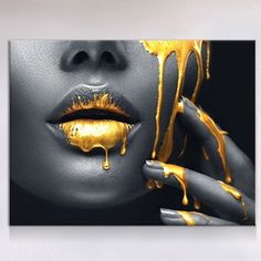 a woman's face with gold paint dripping on her lips and hand holding up the lip