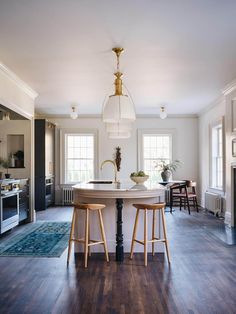 a kitchen with two stools and an island in the middle of the room,