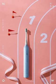 a blue electric toothbrush sitting on top of a pink wall next to white tape