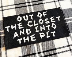 a black and white plaid shirt with the words out of the closet and into the pit on it