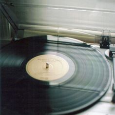 an old record player sitting on top of a white table next to a pair of scissors