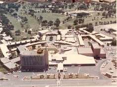 an aerial view of a large building and parking lot in the middle of a city