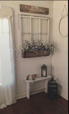 an old window is filled with white flowers and greenery, along with a small table