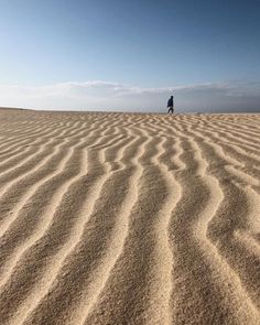 a person standing on top of a sandy hill