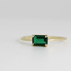 This beautiful East West Emerald Gold Ring was handmade in Melt'm Jewelry Design Studio in California using 14k solid yellow gold band and 6x4mm emerald cut lab grown emerald stone. Emerald is featuring in 14k gold prong setting. DETAILS ABOUT THE RING, MATERIAL AND STONES Ring Band: 14K solid gold Ring Band size: 1.2 mm thick Gemstone: Lab grown Emerald Emerald size: 6mm x 4mm emerald cut Yellow gold or white gold options available from drop down menu. It is a great birthday gift for your speci