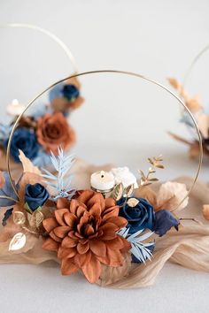 a close up of a flower crown on a white surface with blue and orange flowers