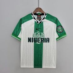 a green and white soccer jersey hanging on a hanger