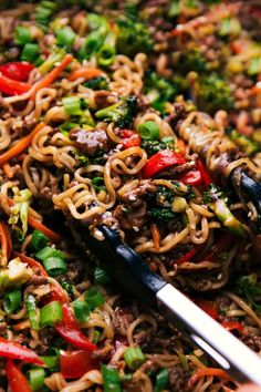 stir fry noodles with beef and vegetables in a skillet, ready to be eaten