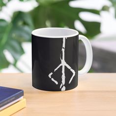 a black and white coffee mug with an arrow drawn on it