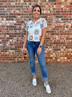 Add some bohemian flair to your wardrobe with our charming crochet top! This vintage-inspired piece features intricate detailing and a button-down front, perfect for warmer days. Embrace elegance with a touch of playfulness in this must-have top. Color: White, Orange and Blue Fabric: 60% Cotton, 40% Acrylic Includes: x1 Top Sizes: S/M, M/L Length: 20" - 20.5"Model is 5'10" and wearing a size small (33-23.5-35) Crochet Trim Short Sleeve Top For Day Out, Crochet Trim Top With Short Sleeves For Day Out, Crochet Top With Crochet Trim For A Day Out, Spring Blouse With Crochet Lace For Day Out, Casual Open Knit Button-up Tops, Bohemian Crochet Top For Fall Day Out, Fall Crochet Top For A Day Out, Bohemian Blouse With Button Closure For Day Out, Casual Crochet Short Sleeve Blouse