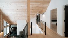 the interior of a house with wood and white walls, wooden flooring and black railings