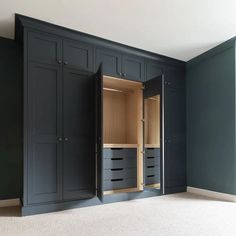 an empty room with blue cabinets and white carpeting on the floor in front of it