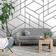 a modern living room with geometric wallpaper and grey couches, potted plant on coffee table