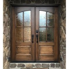 two double doors with glass on each side and stone wall in the backround