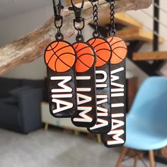 two black and orange key chains with basketballs on them hanging from a tree branch