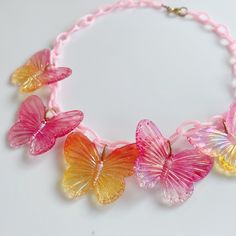 Statement necklaces with dangling bakelite or celluloid charms were extremely popular in the 1940s-50s and often featured flowers, fruit or leaves. This fabulous necklace is designed and handmade by me, inspired by those wild and wacky necklaces of yesteryear. This fabulously kitschy ooak necklace features pink and peach Aurora borealis lucite butterfly charms, hanging from a pink pearlised plastic chain. The necklace fastens with a true vintage brass spring ring clasp. Fluttershy Necklace, Butterfly Charm, Fluttershy, Statement Necklaces, Aurora Borealis, Spring Rings, True Vintage, Vintage Brass, Kitsch